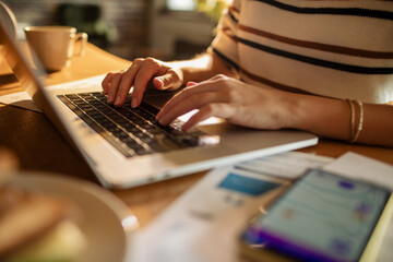 Young woman using a laptop while working from home and going over her home finances and bills
