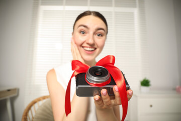 Fototapeta premium Dreams come true. Woman with new gifted camera at home, selective focus