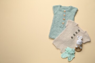 Stylish baby clothes and accessories on beige background, flat lay. Space for text