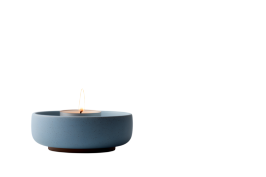  small lit candle floats serenely in blue bowl isolated on white background