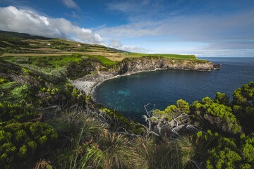 Scenic coastal landscape with lush greenery and a clear blue ocean on Terceira island, Azores