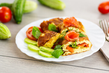 Omelet with salmon and green leaves for a healthy breakfast