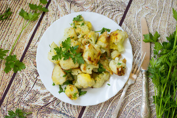 Fried cauliflower with spices and herbs in a frying pan