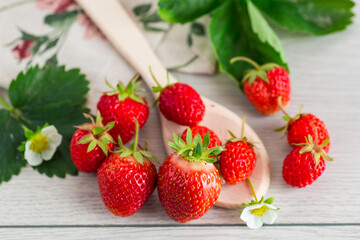Top view of red strawberries on a light wooden table