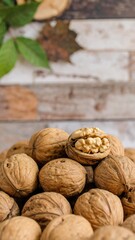 Close-up view of a pile of walnuts, showcasing their rich brown hues and textured shells, with one walnut cracked open to reveal the light-colored kernel inside.