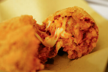 Supplì, a traditional Roman street food, rice croquettes filled with mozzarella 