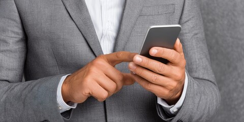 Businessperson engaged with smartphone gray background professional portrait modern environment close-up view digital communication