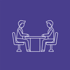 Two individuals engaged in a focused discussion around a table, set against a simple, solid color backdrop