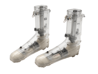 Pair of clear plastic boots with mechanical components, likely for biomechanics or rehabilitation research.  The boots are encased in transparent containers, revealing internal mechanisms.