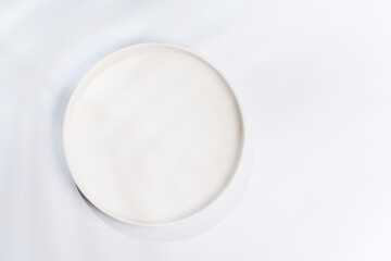 Empty plate on a white background with leaf shadows, perfect food mockup