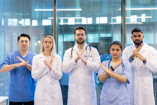 Doctors and nurses showing stop sign with crossed arms - Powered by Adobe