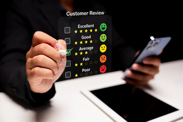 Customer review rating concept. Businessman using digital pen to select average rating from checklist with star and emoji system on virtual interface, holding smartphone near digital tablet.