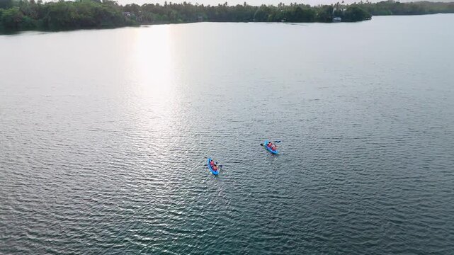 Evening Drone Push In of Two Kayaks Moving Across a Calm Lagoon with Reflections