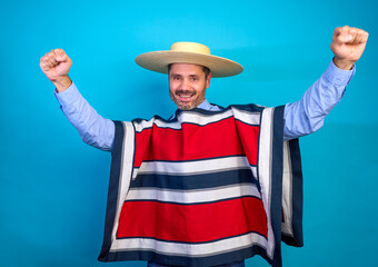 Studio shot of a cheerful chilean man using traditional huaso attire expressing excitement and joy