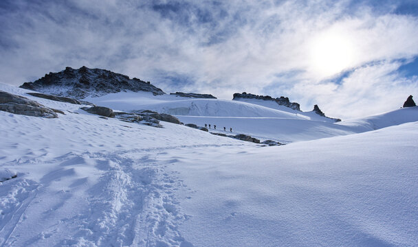 Gran Paradiso National Park, Italy. Climbers on the way to the summit of the mount Gran Paradiso from the Refuge Victor-Emmanuel II. A lot of snow covered a glacier. Sunny chilly day.