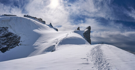 Gran Paradiso National Park, Italy. Climbers on the way to the summit of the mount Gran Paradiso from the Refuge Victor-Emmanuel II. A lot of snow covered a glacier. Sunny chilly day.