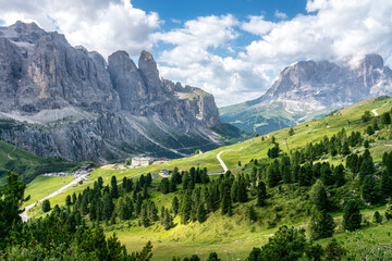 Panoramic view of Gardena Pass with Dolomites peaks and green meadows in summer, Italy
