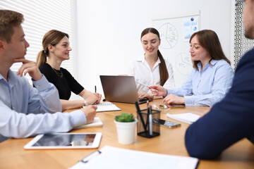 Business coach giving presentation to group of people in office