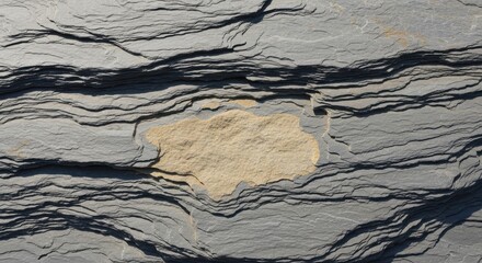 Close up of weathered slate with a lighter stone embedded within