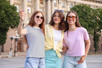 Happy friends walking together on city street