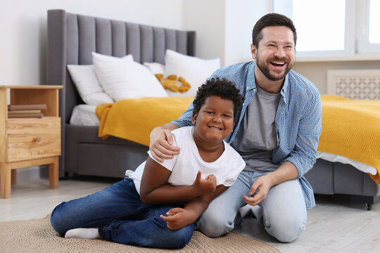 Adoption. Father and his son on floor at home