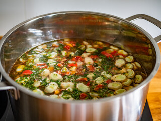 Vegetable soup with broad bean in cooking pot
