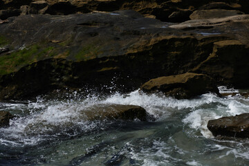 Pacific shore with white wave and blue ocean