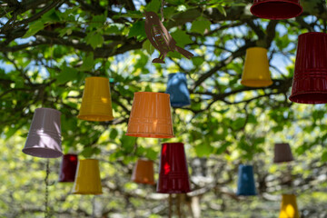 Colorful DIY Garden Decor – Flower Pots and Bird Hanging in Leafy Arbor