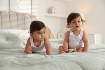 Cute little twin babies on bed at home