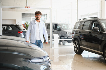 Customer choosing new car in dealership showroom.