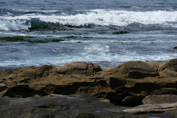 Pacific shore with white wave and blue ocean