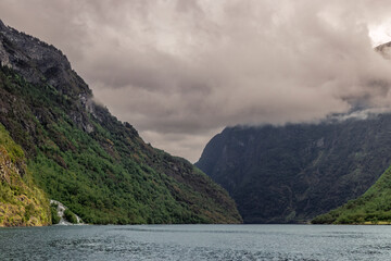 fiordo de Sognerfjord Noruego en un dia lluvioso con sus altas montañas con cascadas de agua y sus...