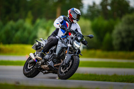 Latvia, Riga, 2025-08-27, regular trainingSpeeding through the serene countryside on a BMW motorcycle, a rider in full gear showcases their skill and passion for the sport