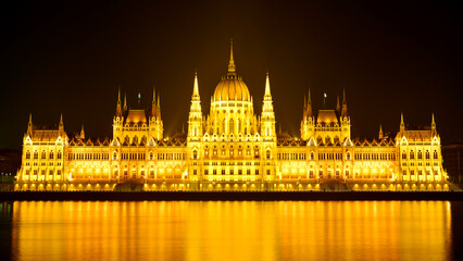 Fototapeta premium The lights of the Hungarian Parliament building reflected on the Danube.