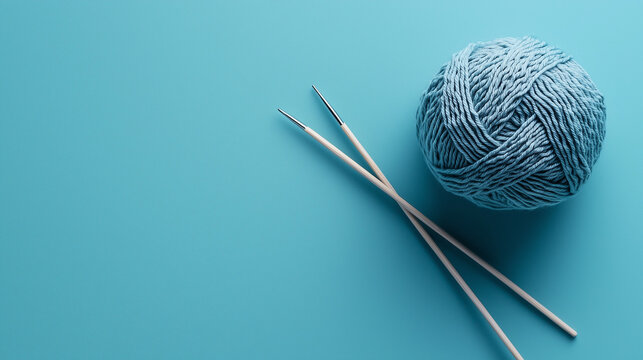 Ball of yarn with knitting needles on a blue background with space for copying. Concept International Day of Older Persons.