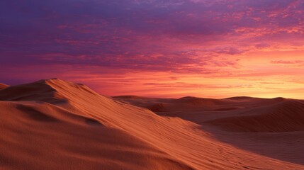 Vast desert landscape with endless sand dunes under a vibrant orange and purple sunset sky