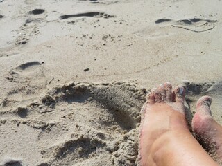 woman feet on the beach during the summer vacation