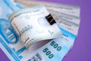 United Arab Emirates dirham money bills in big amount on purple. Finance and banking concept