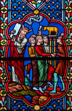 Stained glass (19th century) of the Adoration of the Golden Calf and Moses with tablets of the Law.