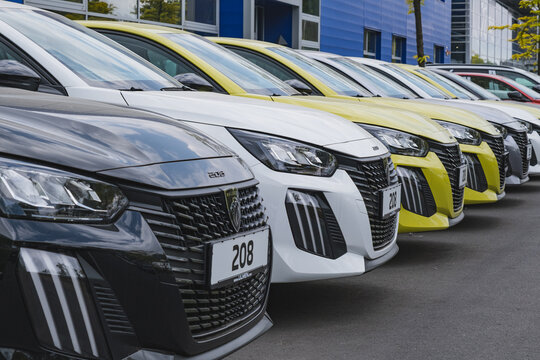 New Peugeot 208 cars parked outside a dealership building