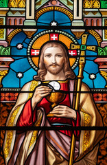 Stained glass (1914) of a portrait of Jesus Christ with the Eucharist.