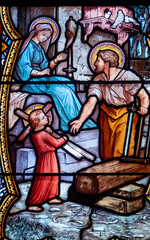 Fototapeta premium Stained glass (19th century) of Holy family: Jesus infant, Virgin Mary and St Joseph in the workshop of Joseph the carpenter.