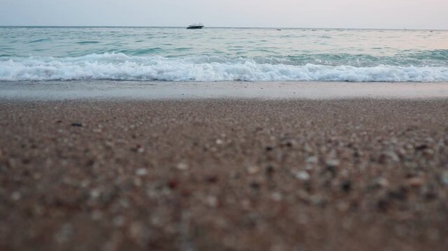 Gentle waves roll onto the sandy beach at Canj as the Mediterranean sun rises over the horizon. The tranquil atmosphere invites peace and relaxation by the water. Adriatic sea.