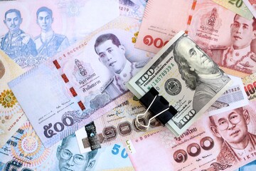 Thai baht currency money bills and bunch of us dollars. The concept of currency exchange