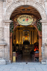 Zapopan, Mexico - June 5 2025: Catholic church doorway decorated for Jubilee 2025, showing bright altar and pews inside, located in the historic center of Zapopan