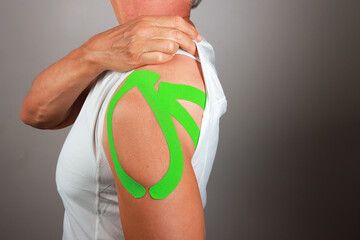 Senior Man with Kinesio tape on his shoulder for chronic pain relief 