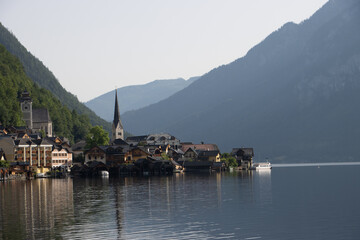 Fototapeta premium Photography of Hallstatt, Austria, showing the picturesque alpine village by the lake, historic houses, mountains in the background, and serene European landscape.