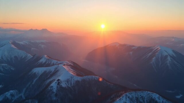 Aerial view panorama of the highlands at sunset. Mountains covered with snow and the setting sun from a bird's eye view