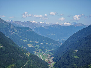 Naklejka premium A Alps mountain range with a town in the valley below