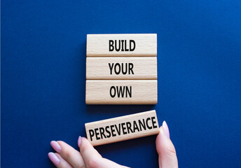 Perseverance symbol. Wooden blocks with words Build your own Perseverance. Businessman hand....